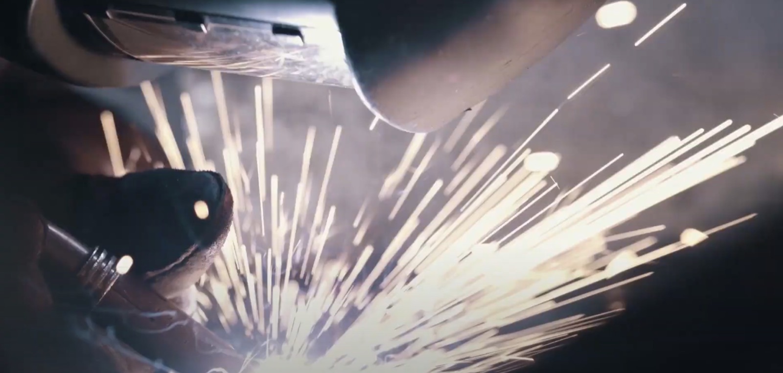 Sparks flying from an angle grinder in a dark workshop